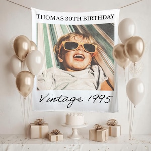 May include: A birthday party scene with a banner that reads "THOMAS 30TH BIRTHDAY" and "Vintage 1995". The banner features a photo of a child wearing sunglasses. Balloons, gifts, and a cake complete the festive setting.