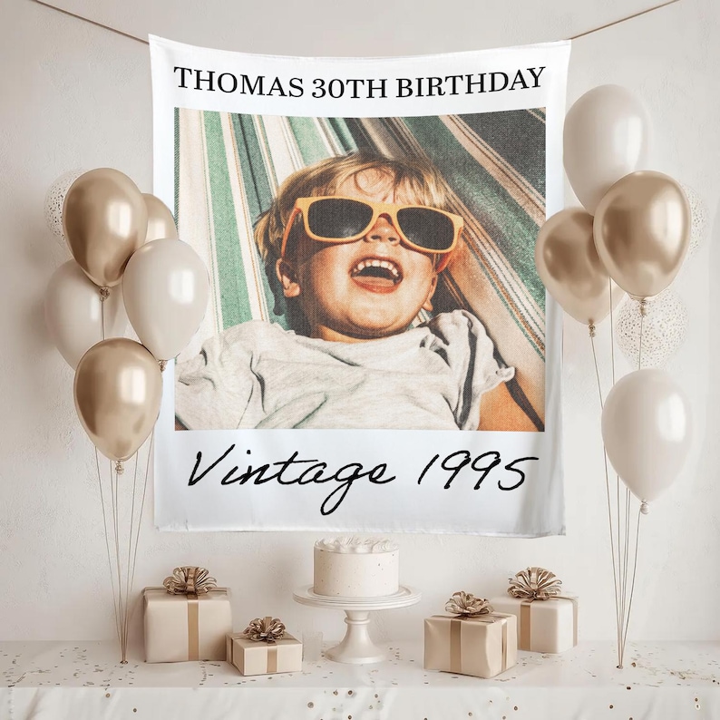 May include: A birthday party scene with a banner that reads "THOMAS 30TH BIRTHDAY" and "Vintage 1995". The banner features a photo of a child wearing sunglasses. Balloons, gifts, and a cake complete the festive setting.