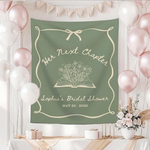 May include: Sage green tapestry with the text "Her Next Chapter" and "Sophia's Bridal Shower" in a decorative frame. The tapestry features an open book with floral illustrations. Balloons and floral arrangements decorate the background.