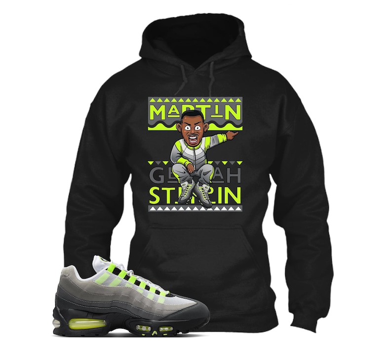 Puede incluir: Sudadera con capucha negra con un gr&aacute;fico de dibujos animados de un hombre se&ntilde;alando, con el texto "MARTIN" y "GEEAH STARIN" en verde ne&oacute;n y blanco. Un par de zapatillas grises, negras y verde ne&oacute;n est&aacute;n en primer plano.