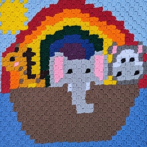 Könnte beinhalten: Ein gehäkelter Regenbogen mit einer Sonne, einem Elefanten, einem Löwen und einem Bären. Die Tiere sitzen alle auf einem braunen Boot.