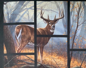 May include: A white-tailed deer buck stands in a woodland setting with autumn foliage. The deer is brown with a white tail and large antlers. The woodland is filled with trees and leaves in shades of brown, yellow, and orange.