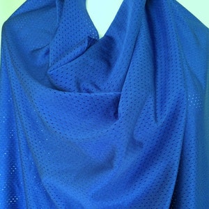 Peut inclure: Un tissu en maille athl&eacute;tique bleu roi vif pr&eacute;sentant un motif coh&eacute;rent de petits trous de ventilation r&eacute;guli&egrave;rement espac&eacute;s sur tout le mat&eacute;riau. Le textile est drap&eacute; pour montrer sa texture l&eacute;g&egrave;re, respirante et semi-transparente.