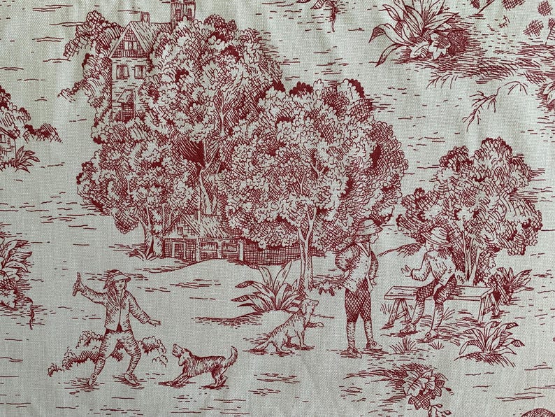 Puede incluir: Una tela de color crema con un patr&oacute;n toile repetitivo en tinta roja oscura. El dise&ntilde;o representa una escena pastoral con casas, &aacute;rboles grandes y figuras de personas interactuando con perros en un entorno natural.