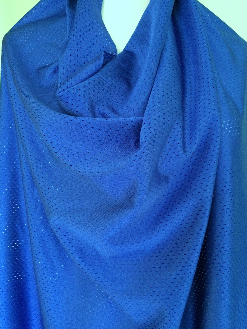 Peut inclure: Un tissu en maille athl&eacute;tique bleu roi vif pr&eacute;sentant un motif coh&eacute;rent de petits trous de ventilation r&eacute;guli&egrave;rement espac&eacute;s sur tout le mat&eacute;riau. Le textile est drap&eacute; pour montrer sa texture l&eacute;g&egrave;re, respirante et semi-transparente.