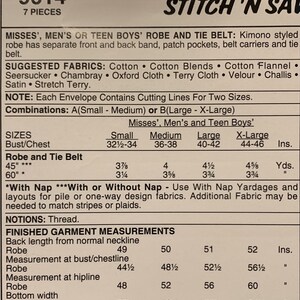 May include: A sewing pattern envelope labeled 9614 STITCH 'N SAVE for a kimono-style robe and tie belt. The text details 7 pieces, suggested fabrics, size combinations from Small to X-Large, yardage requirements in inches, and finished garment measurements.