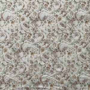 May include: A fabric featuring a dense, repeating floral pattern in shades of beige, taupe, and muted green on an off-white background. The design consists of large, layered rose blossoms interspersed with smaller clusters of tiny flowers and leaves.