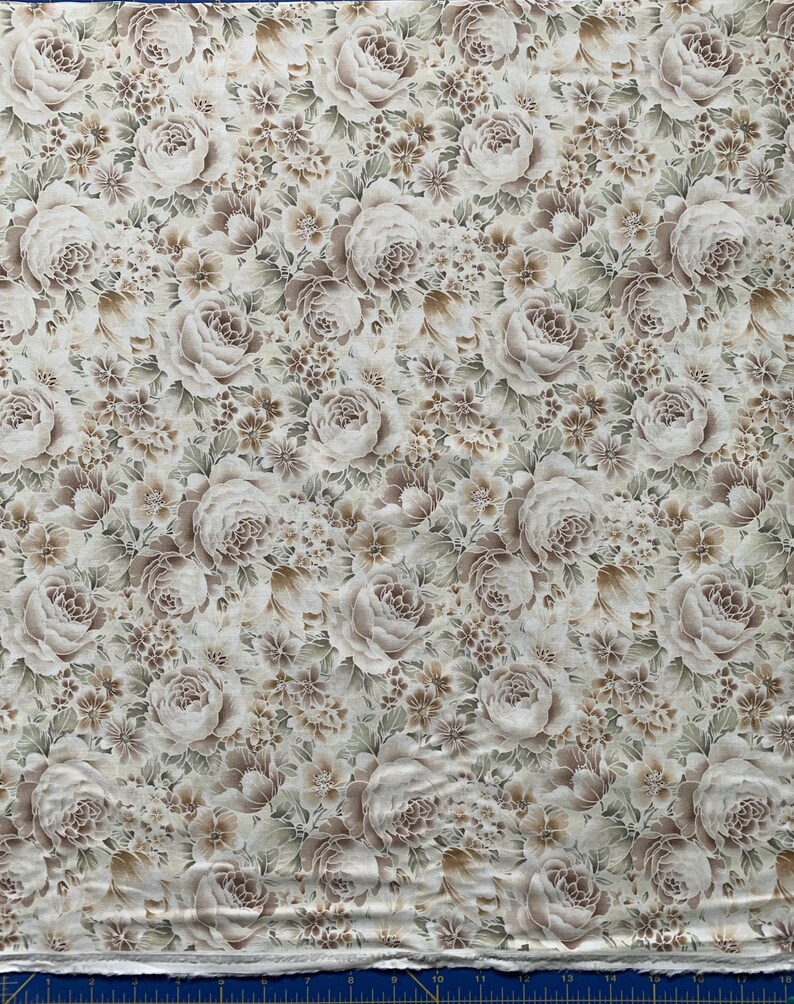 May include: A fabric featuring a dense, repeating floral pattern in shades of beige, taupe, and muted green on an off-white background. The design consists of large, layered rose blossoms interspersed with smaller clusters of tiny flowers and leaves.