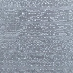 May include: A close-up of a gray fabric with a textured pattern. The fabric features horizontal wavy lines and small diamond-shaped white accents, creating a subtle, elegant design. The overall appearance is soft and flowing.