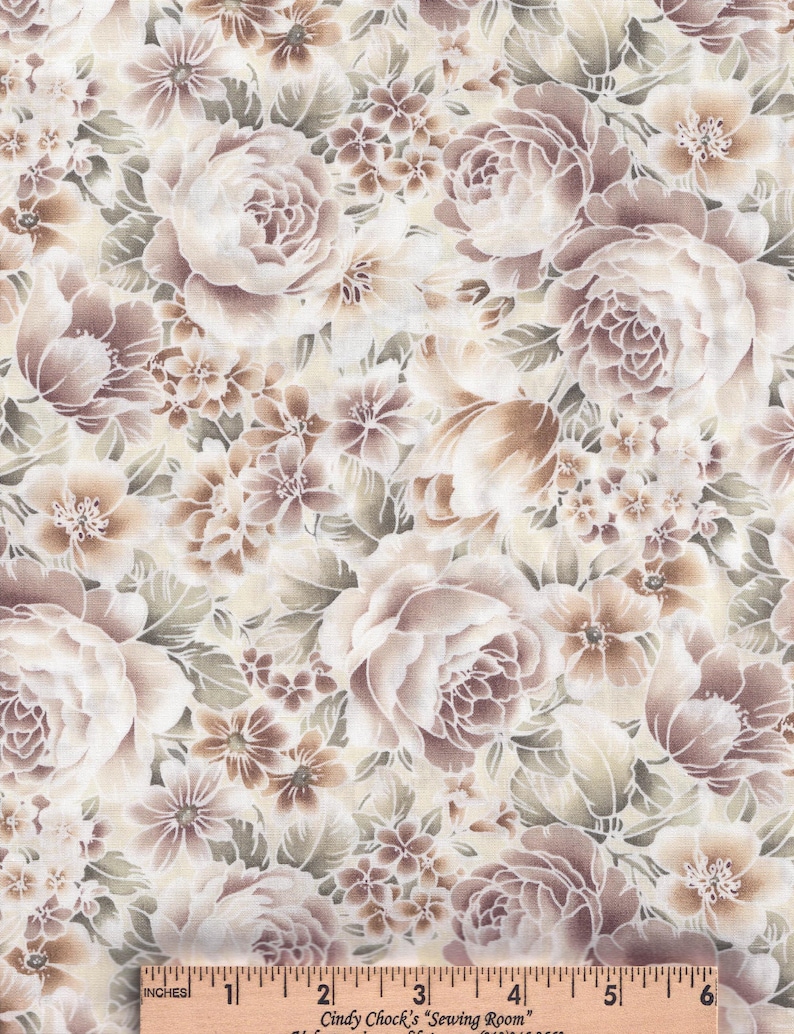 May include: A fabric featuring a dense floral pattern in shades of mauve, brown, and cream. The design includes large, layered rose-like blossoms and smaller filler flowers with green foliage. A wooden ruler measuring 6 inches is visible at the bottom.