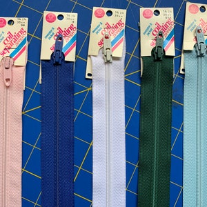 Può includere: Sei cerniere separabili a bobina da 14 pollici in diversi colori. Le cerniere sono confezionate su schede con il testo "cerniera separabile a bobina" e "maglione e giacca".