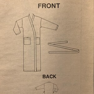 May include: A McCall's Stitch 'N Save 9614 sewing pattern envelope featuring a line drawing of a robe with long sleeves, two front pockets, and a separate tie belt. The design shows both front and back views of the garment on a tan background.