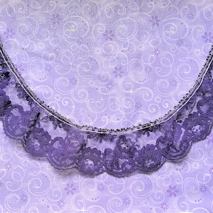 Puede incluir: Borde de encaje morado con un borde festoneado sobre un fondo morado con un patrón de espiral.