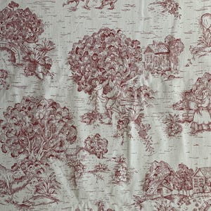 Puede incluir: Una tela de color crema con un patr&oacute;n toile de color rojo oscuro repetitivo. El dise&ntilde;o muestra escenas pastorales con casas, puentes de piedra arqueados, &aacute;rboles grandes, figuras con ropa de &eacute;poca y varios animales como ovejas.