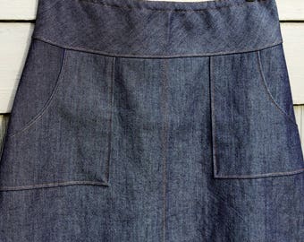 Saia jeans escura: corte A com bolsos tipo avental, ajuste personalizado