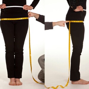 May include: A person wearing black pants and a black top is having their hip measurement taken with a yellow measuring tape. The person is standing in front of a white background. The image shows both a front and side view of the person.