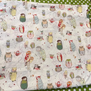 May include: White fabric with a repeating pattern of colorful owls in various poses, connected by whimsical lines. The owls feature a range of colors including green, red, yellow, and brown. The fabric is set against a green polka dot background.