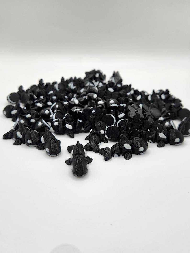 K&ouml;nnte beinhalten: Ein gro&szlig;er Haufen kleiner schwarzer und wei&szlig;er Plastik-Orca-Figuren. Die Orcas haben wei&szlig;e Markierungen auf R&uuml;cken und Bauch.
