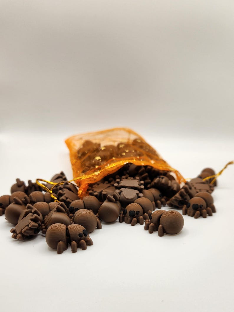 May include: A bag of small brown spiders with black eyes, spilling out of an orange mesh bag onto a white surface.