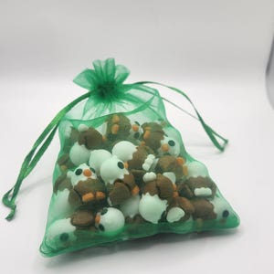 May include: A green mesh bag filled with small brown and white owl figurines.