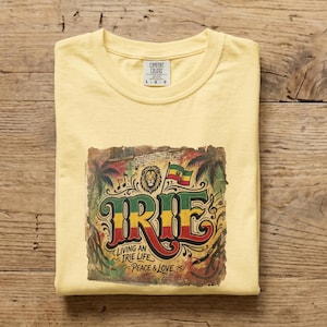 May include: Yellow Comfort Colors t-shirt with a colorful graphic. The graphic features the word "IRIE" in red, yellow, and green, along with a lion, palm trees, and the text "Living an Irie Life Peace & Love."