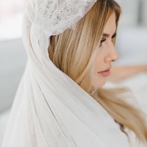 May include: A white bridal veil with a delicate lace trim. The veil is made of soft tulle and is perfect for a wedding ceremony.