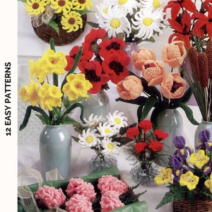 May include: A collection of 12 crochet flower patterns. The image shows a variety of crocheted flowers in different colors and styles, including daisies, tulips, daffodils, lilies, and carnations. The flowers are arranged in vases and baskets.