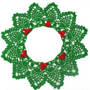 Puede incluir: Corona de Navidad de crochet verde con acentos de bayas rojas.