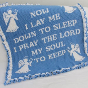 Puede incluir: Una manta de bebé de crochet azul con ángeles de crochet blanco y el texto "NOW I LAY ME DOWN TO SLEEP I PRAY THE LORD MY SOUL TO KEEP".