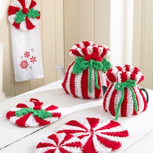 May include: Set of five crocheted peppermint-themed kitchen accessories, including a teapot cozy, a smaller cozy, a dish towel, and two pot holders. The accessories are red and white striped with green accents.