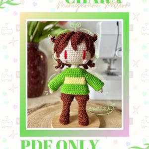 May include: A crocheted Chara amigurumi doll with brown hair, red eyes, and a green and yellow sweater. The doll is wearing brown pants and boots. The image includes the text "CHARA Minigurumi Pattern" and "PDF ONLY".