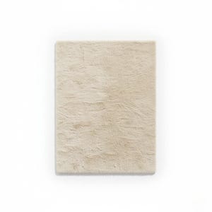 May include: A rectangular, beige rug with a soft, textured surface. The rug has a plush appearance and is likely made of a soft material. The neutral color makes it suitable for various interior design styles.