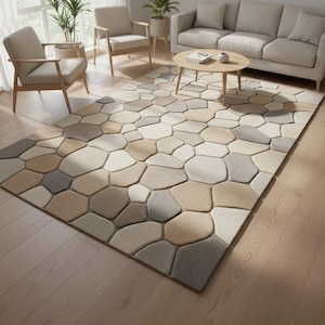 Könnte beinhalten: Ein rechteckiger Teppich mit einem Kieselsteinmuster in Beige-, Grau- und Beigetönen. Der Teppich, der auf einem Holzboden liegt, dominiert den Wohnraum. Das Design des Teppichs ahmt eine Ansammlung glatter Steine nach.