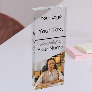 May include: A clear acrylic award with a photo of a woman wearing a headset and a beige blazer. The text on the award reads "Your Logo", "Your Text", "Awarded to", and "Your Name".