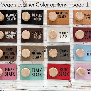 May include: A selection of vegan leather colour options with wooden knobs. The image displays various colour combinations, including black/silver, black/gold, bamboo/black, and engraved cork. The text "Vegan Leather Color options - page 1" is at the top.