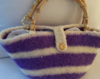 A crocheted felted purse with a bamboo handle.