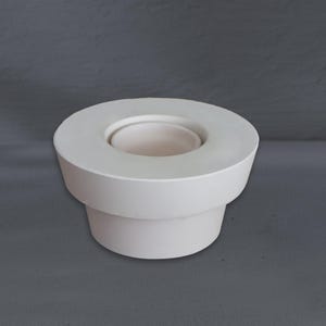 Op de afbeelding: Een witte keramische kandelaar met een cirkelvormige bovenkant en een cilindrische basis. De kandelaar heeft een minimalistisch ontwerp en een gladde, matte afwerking. De binnenkant is een kleinere, verzonken cirkel.