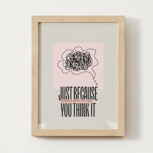 Op de afbeelding: Een ingelijste print met een roze achtergrond en zwarte tekst die luidt "Just because doesn't mean it's true you think it". De print bevat een zwart-witte illustratie van een gedachteballon met een wirwar van lijnen erin.