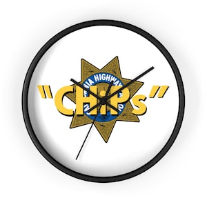 May include: A round wall clock with a black frame and a white face. The clock features the California Highway Patrol badge at the center, with the word "CHiPs" in yellow. The clock hands are black.
