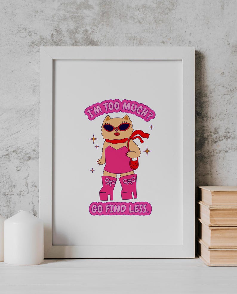 Puede incluir: Una impresi&oacute;n enmarcada en blanco con un gato de dibujos animados rosa que lleva gafas de sol y un vestido rosa. El texto de la impresi&oacute;n dice "&iquest;Soy demasiado? Ve a buscar menos."