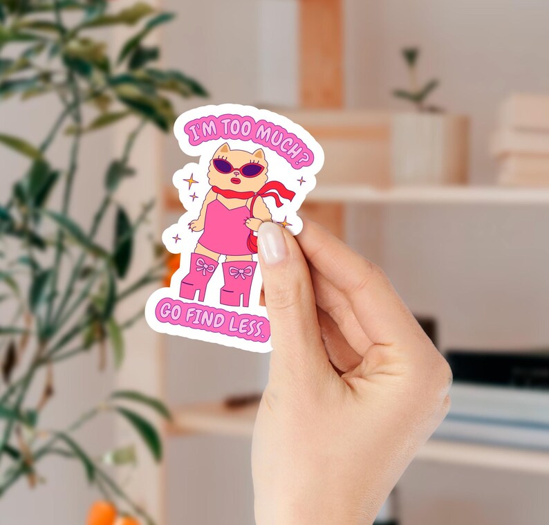 Puede incluir: Una pegatina rosa y blanca con un perro de dibujos animados que lleva gafas de sol y un vestido rosa. El texto de la pegatina dice "&iquest;Soy demasiado? Ve a buscar menos."