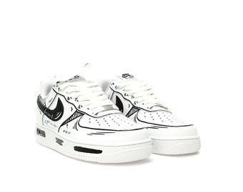 May include: White leather low-top trainers with black doodle-style details and a black Nike swoosh. The shoes have a white midsole and a black outsole.