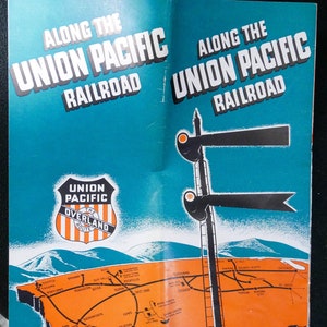 May include: A vintage travel brochure for the Union Pacific Railroad. The brochure features the text "Along the Union Pacific Railroad" in bold white letters on a teal background. A map of the railroad route is displayed in orange, with major cities labeled.