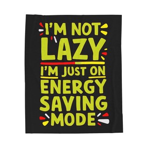 May include: Black throw blanket with yellow text that reads "I'm not lazy, I'm just on energy saving mode".