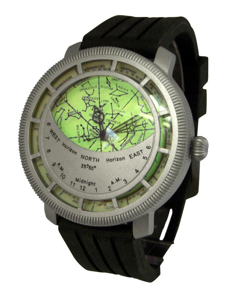 May include: A silver-toned wristwatch with a black rubber band. The watch face features a green star chart with constellations and a compass-like dial with the words "West Horizon", "North 35&deg;50&deg;", "East Horizon", and "Midnight".