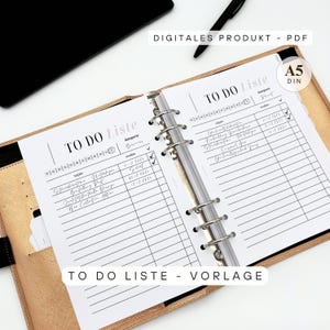 Könnte beinhalten: A5-Format To-Do-Listen-Vorlage in einem goldfarbenen Ordner. Die weißen Seiten zeigen schwarzen Text, darunter "TO DO Liste" und "DIGITALES PRODUKT - PDF". Die Vorlage enthält Abschnitte für Aufgaben, Fristen und Kategorien.