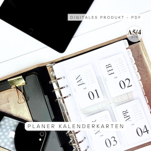 May include: A gold-colored planner with white calendar cards for January, February, March, and April. The cards display the numbers 01, 02, 03, and 04, along with the year 2026. The text "PLANER KALENDERKARTEN" is visible.