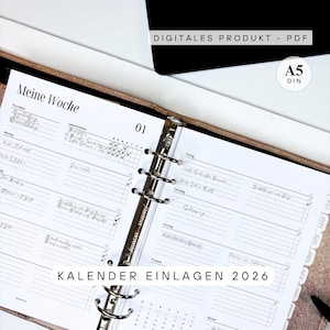 Könnte beinhalten: Geöffneter Planer mit Wochenlayout, mit dem Text "Meine Woche" und "KALENDER EINLAGEN 2026". Die Seiten sind weiß mit schwarzem Text und einem silbernen Ordner. Der Planer hat das Format A5 und der Text "DIGITALES PRODUKT - PDF" ist sichtbar.