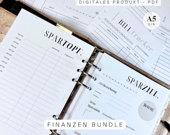 May include: A planner with financial tracking pages. The pages are white with black text, including "SPARTOPF" and "SPARZIEL." The planner is open, revealing lined pages for financial planning. The text "DIGITALES PRODUKT - PDF" is visible.