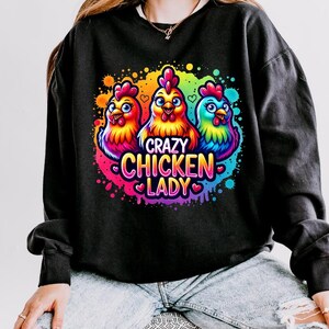 May include: Black sweatshirt with a colorful graphic of three cartoon chickens and the text "Crazy Chicken Lady".